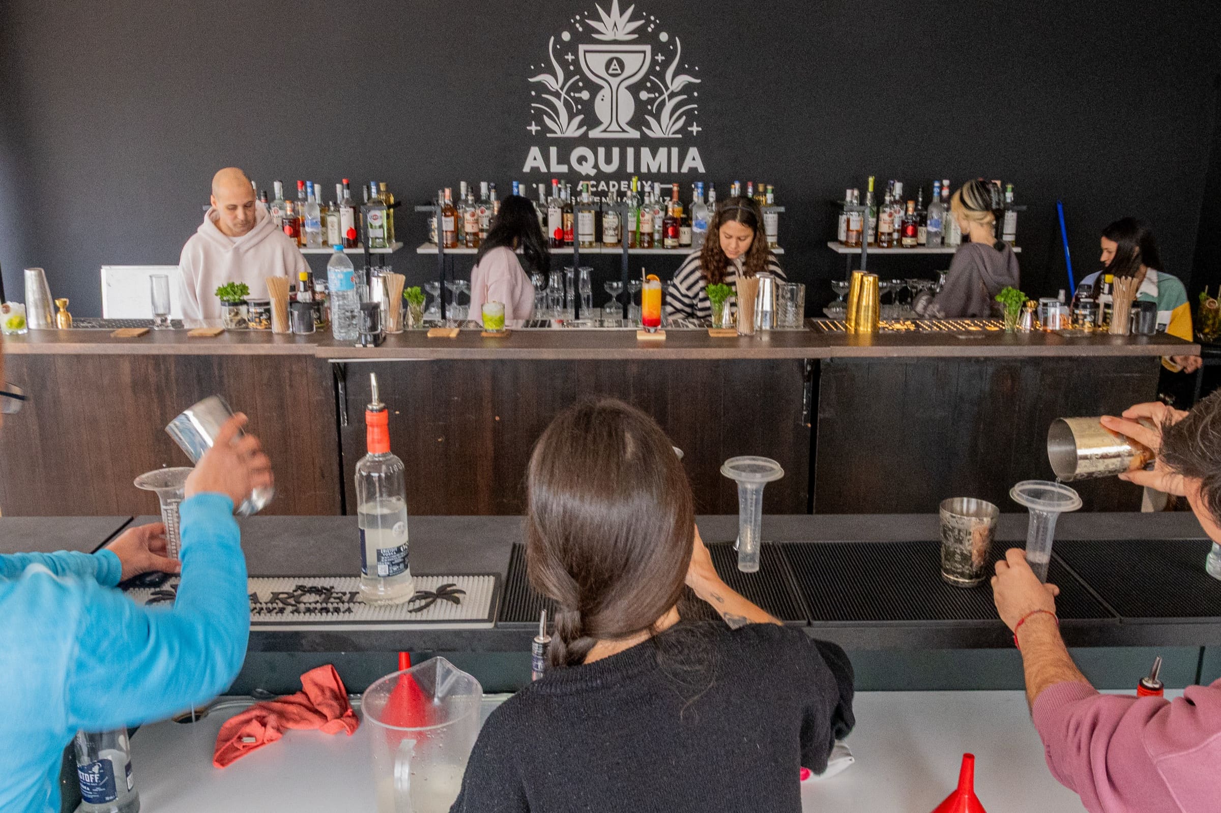 Students practising at the Green Jar lab bar during an Alquimia Academy course.